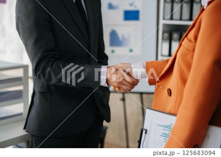 Two confident business man shaking hands during a meeting in the office, success, dealing, greeting and partner 125683094
