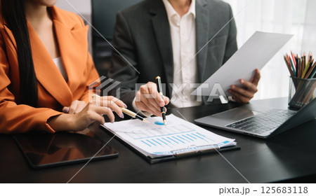 Businessman and team analyzing financial statement Finance task. with smart phone and laptop and  tablet. Wealth management concept 125683118