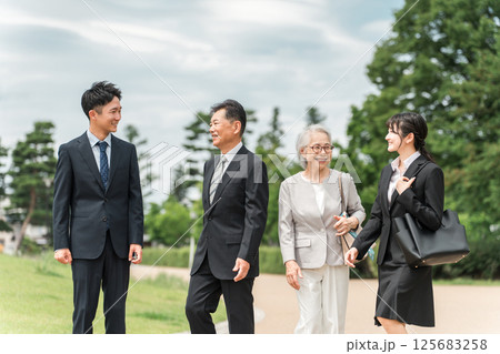スーツ姿の若者とシニアの男女ビジネスマン（M&A・後継者・事業継承・跡取り・売却・買収・世代交代） 125683258