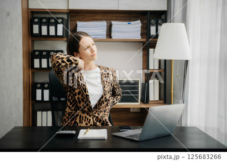 Overworked young Caucasian businesswoman office worker suffering from neck pain after had a long day at her desk. office syndrome concept 125683266