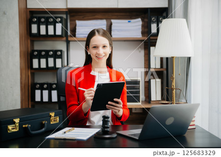 justice and law concept.Female judge in a courtroom on wooden table and Counselor or Female lawyer working in office. justice and law concept.Female judge in a courtroom on wooden table and Counselor or Female lawyer working in office. 125683329