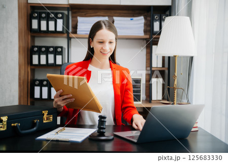 justice and law concept.Female judge in a courtroom on wooden table and Counselor or Female lawyer working in office. justice and law concept.Female judge in a courtroom on wooden table and Counselor or Female lawyer working in office. 125683330