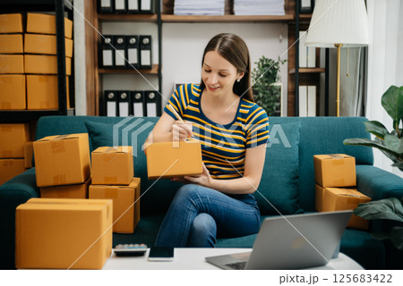 Caucasian young woman SME working using smartphone or tablet taking receive and checking online purchase shopping order to freelance online concept. Caucasian young woman SME working using smartphone or tablet taking receive and checking online purchase shopping order to freelance online concept. 125683422