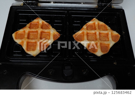 ワッフルメーカーで小ぶりなワッフルを焼いているところ 125683462