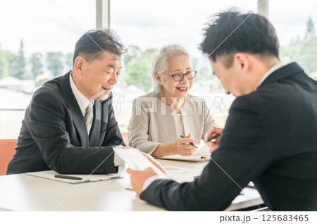 提案された書類を確認する高齢者夫婦(資産運用・相談・投資・遺産) 提案された書類を確認する高齢者夫婦(資産運用・相談・投資・遺産) 125683465