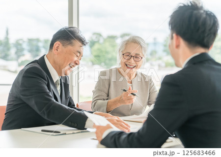 提案された書類を確認する高齢者夫婦（資産運用・相談・投資・遺産） 125683466