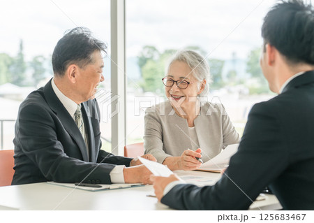 提案された書類を確認する高齢者夫婦(資産運用・相談・投資・遺産) 提案された書類を確認する高齢者夫婦(資産運用・相談・投資・遺産) 125683467