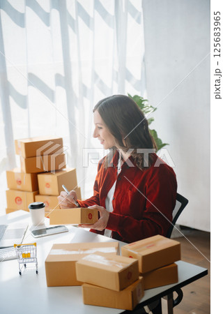 Young business owner woman prepare parcel box and standing check online orders for deliver to customer on tablet, laptop Shopping Online concept. 125683965