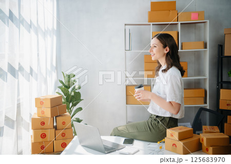 Young women selling clothes on video streaming.Startup small business SME, using smartphone or tablet taking receive and checking. Fashion blogger concept Young women selling clothes on video streaming.Startup small business SME, using smartphone or tablet taking receive and checking. Fashion blogger concept 125683970