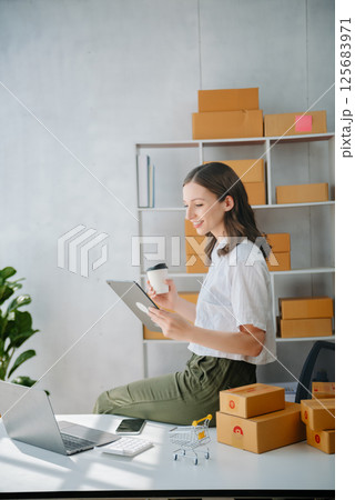 Young women selling clothes on video streaming.Startup small business SME, using smartphone or tablet taking receive and checking. Fashion blogger concept Young women selling clothes on video streaming.Startup small business SME, using smartphone or tablet taking receive and checking. Fashion blogger concept 125683971