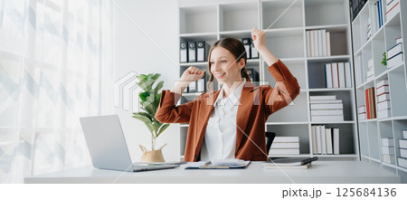 business woman are delighted and happy with the work they do on their tablet, laptop and taking notes business woman are delighted and happy with the work they do on their tablet, laptop and taking notes 125684136