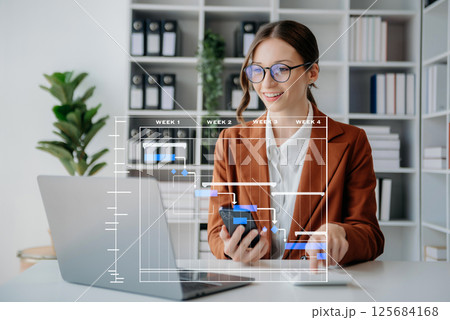 Project manager working and update tasks with milestones progress planning and Gantt chart scheduling diagram. business working with smart phone, tablet and laptop 125684168