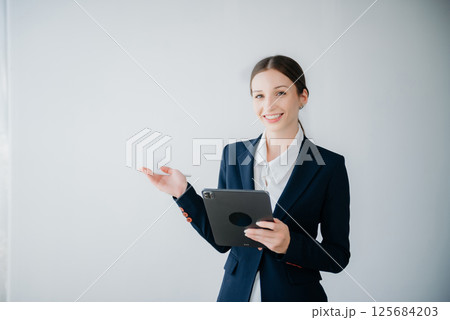 Smiling caucasian young businesswoman bank employee worker manager boss ceo looking at camera, using tablet, laptop and notepad online isolated background Smiling caucasian young businesswoman bank employee worker manager boss ceo looking at camera, using tablet, laptop and notepad online isolated background 125684203