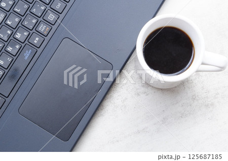 淹れたてのコーヒーを飲みながら、ノートパソコンでリモートワークをしているイメージ写真 125687185