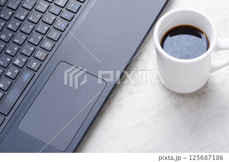 淹れたてのコーヒーを飲みながら、ノートパソコンでリモートワークをしているイメージ写真 淹れたてのコーヒーを飲みながら、ノートパソコンでリモートワークをしているイメージ写真 125687186