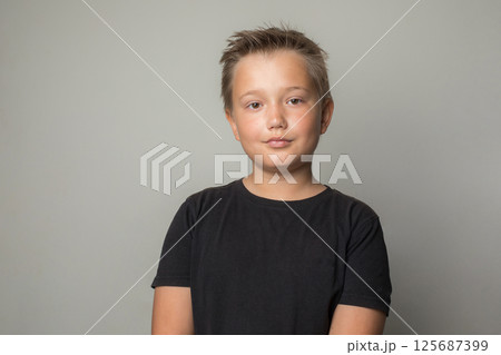 Serious child boy in black t-shirt on white background Serious child boy in black t-shirt on white background 125687399