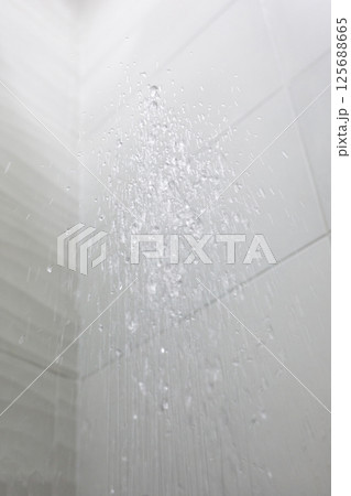 Water flowing on background of white ceramic tiles indoor Water flowing on background of white ceramic tiles indoor 125688665