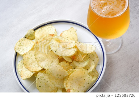 のり塩味のポテトチップスと、よく冷えたビールのグラス のり塩味のポテトチップスと、よく冷えたビールのグラス 125688726