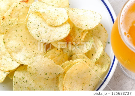 のり塩味のポテトチップスと、よく冷えたビールのグラス のり塩味のポテトチップスと、よく冷えたビールのグラス 125688727