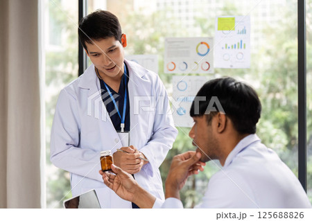 Doctor discussing prescription medication with a colleague 125688826