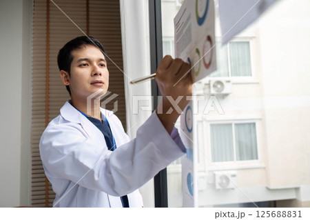 Doctor presenting data insights on charts in a hospital meeting 125688831