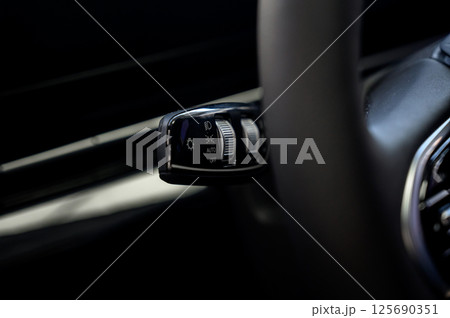 Close up view of car light switch control. Headlight switch, turn signal lever 125690351