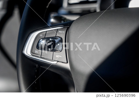 A close-up of a modern car's steering wheel with control buttons A close-up of a modern car's steering wheel with control buttons 125690396