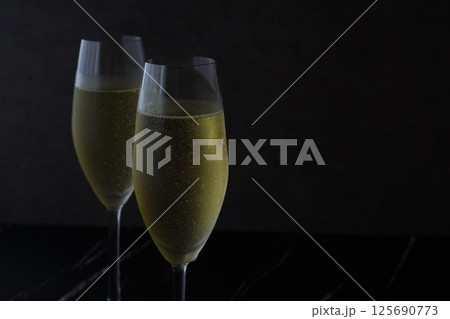 よく冷えたシャンパン（スパークリングワイン）が注がれたふたつのフルートグラスで、乾杯のイメージ 125690773