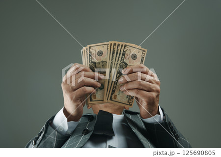 businessman, seen from below, with some dollars 125690805
