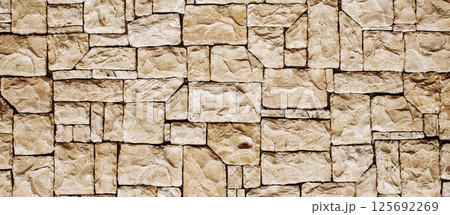 Closeup texture of natural stone wall suitable for construction, architecture, and design projects. Ideal for backgrounds in eco-friendly and rustic themes Closeup texture of natural stone wall suitable for construction, architecture, and design projects. Ideal for backgrounds in eco-friendly and rustic themes 125692269