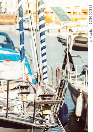 Sailboat deck with striped sails and harbor background 125692315