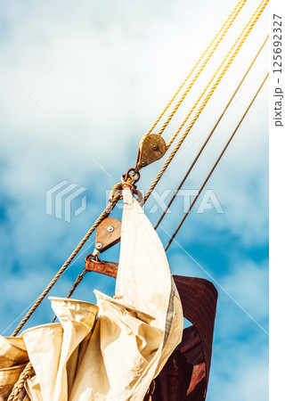 Sailboat rigging against clear blue sky, showcasing nautical elements 125692327