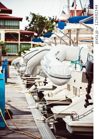 Sailboats moored at marina with inflatable dinghies, nautical theme, background 125692344