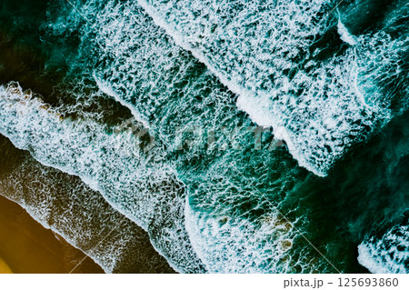 Top view Dark waves crashing on sandy shore beach background,Amazing waves sea nature background Top view Dark waves crashing on sandy shore beach background,Amazing waves sea nature background 125693860