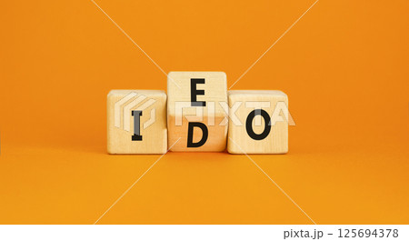 Initial exchange or DEX offering symbol. Concept words abbreviation IEO or IDO on wooden block. Beautiful orange table orange background. Business Initial exchange or DEX offering concept. Copy space. Initial exchange or DEX offering symbol. Concept words abbreviation IEO or IDO on wooden block. Beautiful orange table orange background. Business Initial exchange or DEX offering concept. Copy space. 125694378