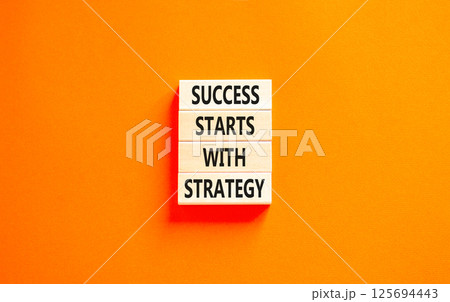 Success starts with strategy symbol. Concept words Success starts with strategy on beautiful wooden blocks. Beautiful orange background. Business and success starts with strategy concept. Copy space. 125694443