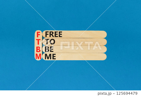 FTBM Free To Be Me symbol. Concept word FTBM Free To Be Me on beautiful wooden sticks. Beautiful blue background. Business motivational FTBM Free To Be Me concept. Copy space. 125694479