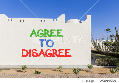 Agree to disagree symbol. Concept words Agree to disagree on beautiful white wall. Beautiful white wall blue sky background. Business and agree to disagree concept. Copy space. Agree to disagree symbol. Concept words Agree to disagree on beautiful white wall. Beautiful white wall blue sky background. Business and agree to disagree concept. Copy space. 125694539