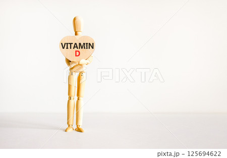 Vitamin D symbol. Concept words Vitamin D on beautiful wooden heart. Doctor's model. Beautiful white background. Copy space. Medical healthy lifestyle Vitamin D concept. Vitamin D symbol. Concept words Vitamin D on beautiful wooden heart. Doctor's model. Beautiful white background. Copy space. Medical healthy lifestyle Vitamin D concept. 125694622