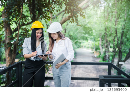 Confident team of female architect working together at terrace. They discussing about new startup project. Architect discuss with engineer about project . Architectural concept. Confident team of female architect working together at terrace. They discussing about new startup project. Architect discuss with engineer about project . Architectural concept. 125695400