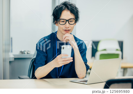 スマホを見て考えるビジネスマン 125695980