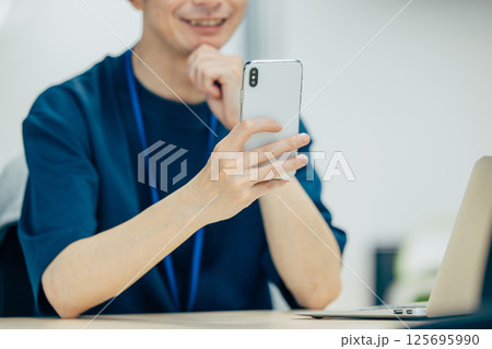 スマホを操作する男性の手元 スマホを操作する男性の手元 125695990
