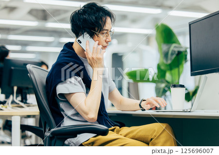 オフィスで電話する若いビジネスマン 125696007