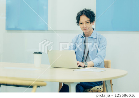 パソコンで作業をする若い男性 125696016