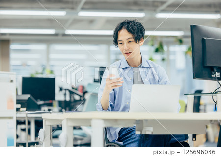 オフィスで働くエンジニア　通話 125696036