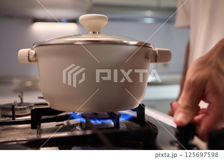 Preparing meals on the stove using a pot can be a delightful culinary experience Preparing meals on the stove using a pot can be a delightful culinary experience 125697598