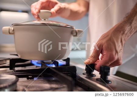 Preparing meals on the stove using a pot can be a delightful culinary experience Preparing meals on the stove using a pot can be a delightful culinary experience 125697600