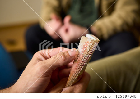A Cash Transaction That Carries Unsettling and Uneasy Undertones of Tension and Anxiety A Cash Transaction That Carries Unsettling and Uneasy Undertones of Tension and Anxiety 125697949