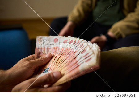 A Cash Transaction That Carries Unsettling and Uneasy Undertones of Tension and Anxiety 125697951