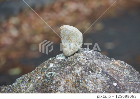 大きな岩にバランスよく立てられた小さな小石 125698065